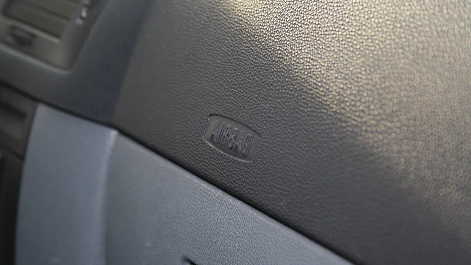 Étiquette « AIRBAG » embossée sur la planche de bord côté passager d'une Škoda Fabia.
