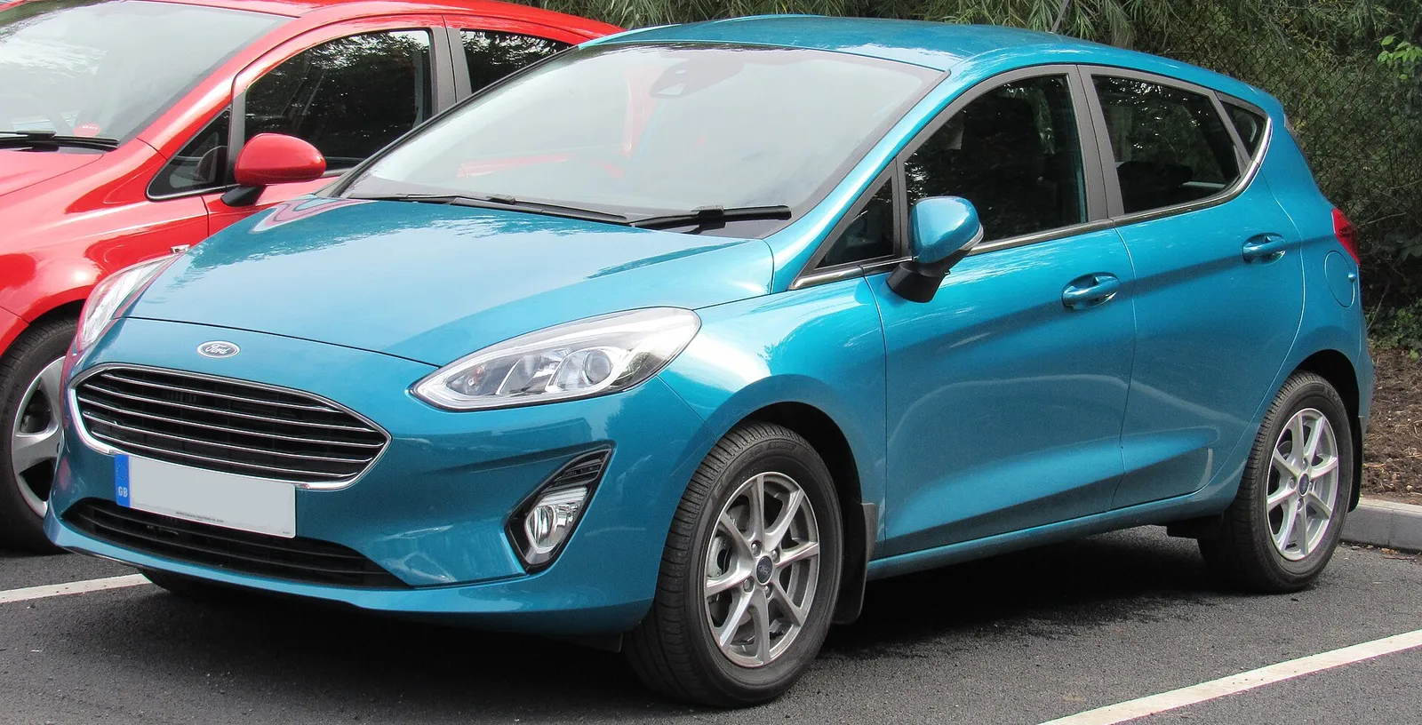 Ford Fiesta VII (2017) bleue vue de trois-quarts avant, garée sur un parking.
