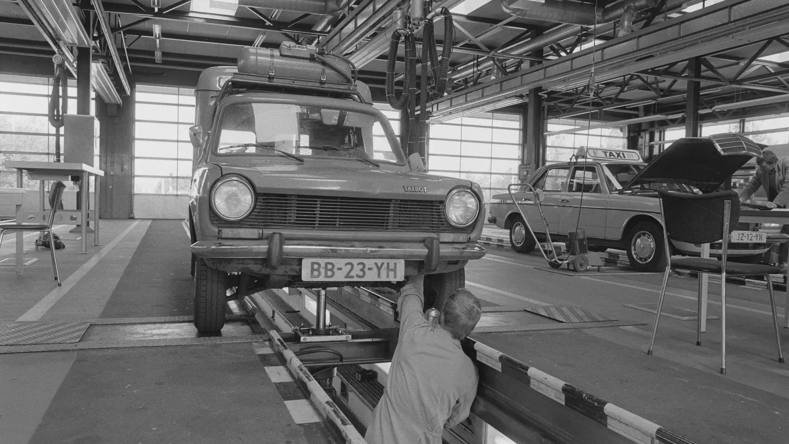 Contrôle technique d'une automobile sur une ligne d'inspection, photographie d'archive en noir et blanc.